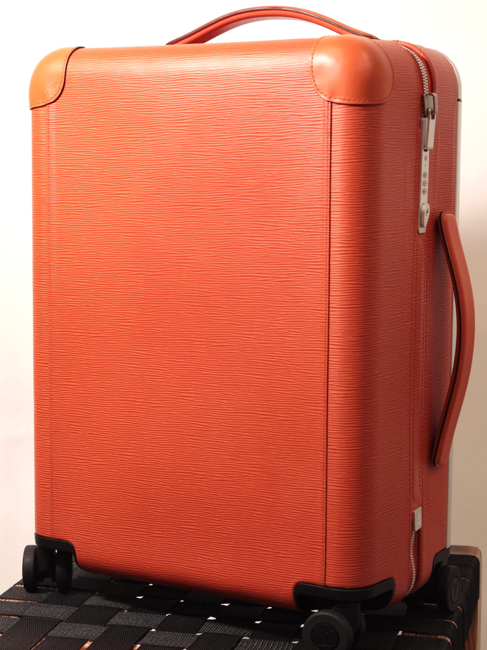 The same orange grained-leather cabin suitcase after restoration, the leather recoloured and the surface even.